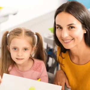 Level 3 Extended Diploma Early Years Educator learner reading a picture book with toddlers in a nursery